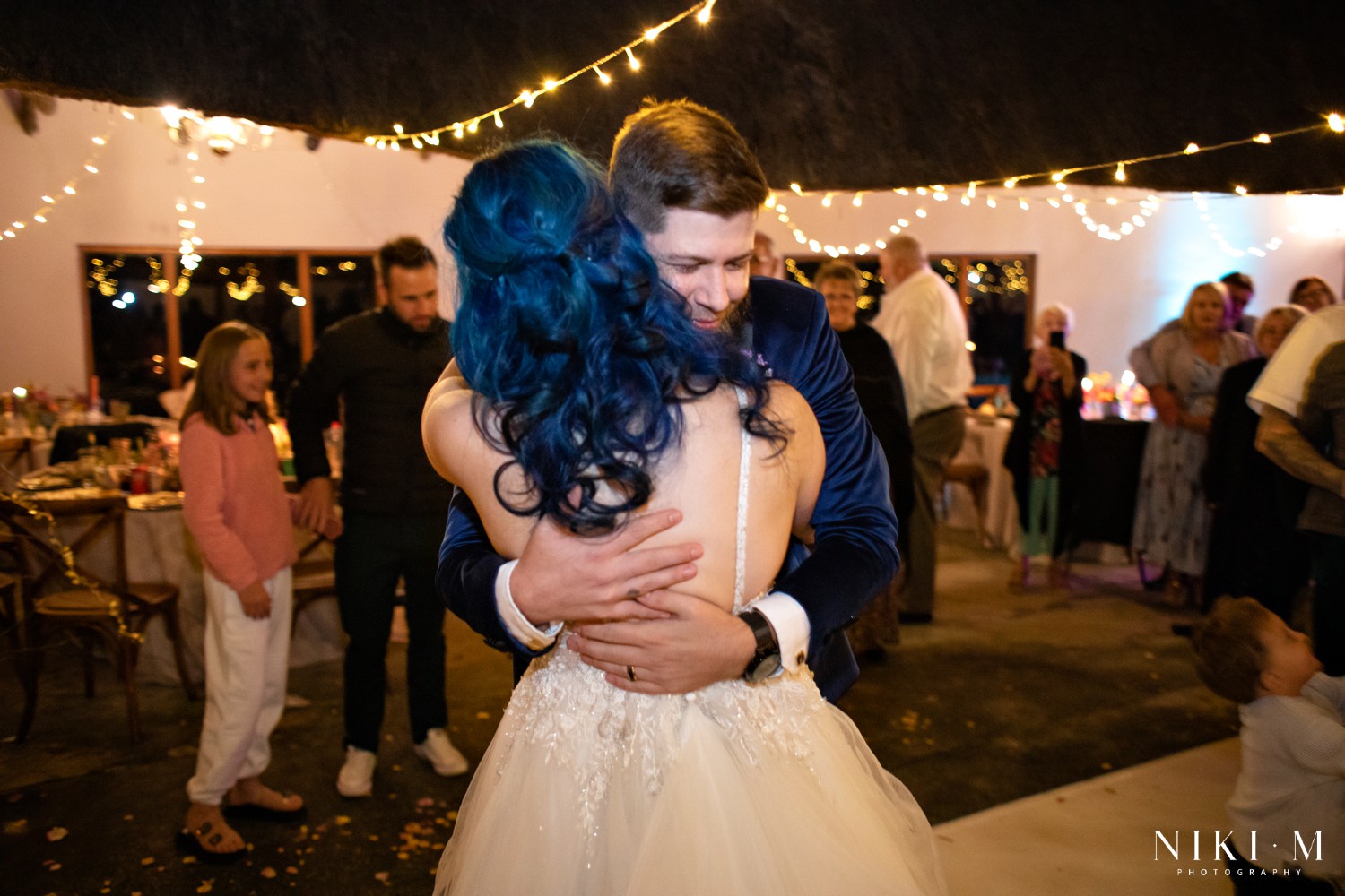 Bride and groom at the centre of a sparkler circle held by their guests at a Champagne Valley Drakensberg wedding