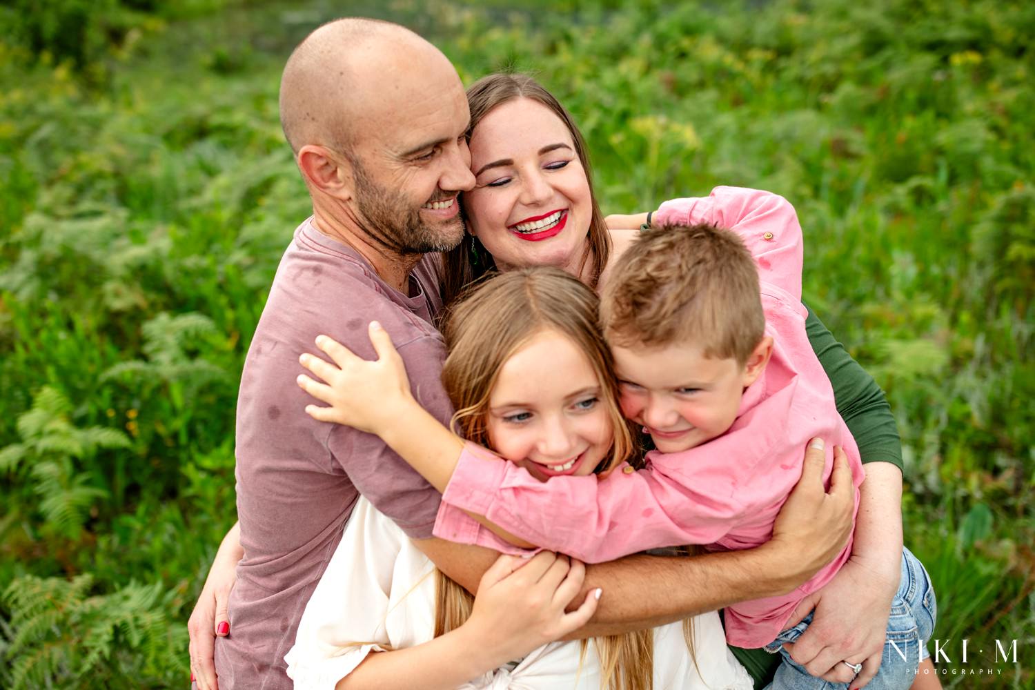 Tender family embrace surrounded by ferns during a Drakensberg family photoshoot at Monks Cowl