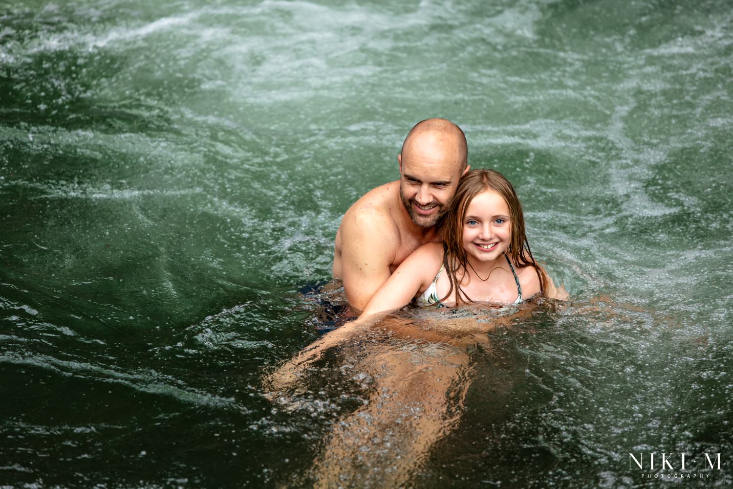 Father and daughter swimming in the natural whirlpool at the Monks Cowl rock pools, Drakensberg