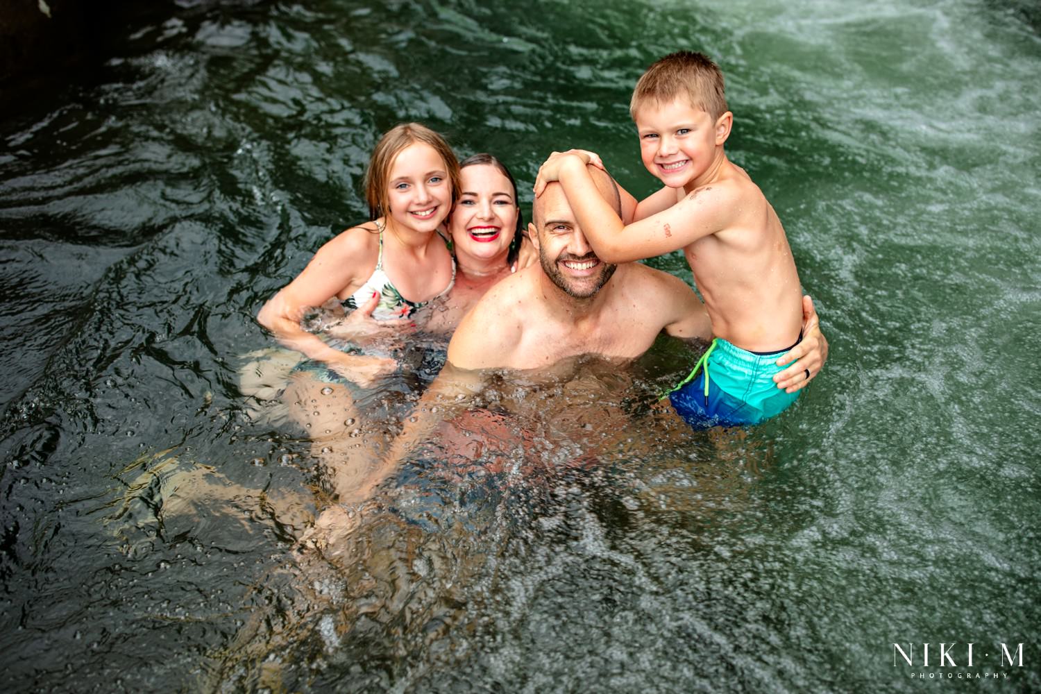 Sharne and Ryan with their family in the Monks Cowl rock pools during their Drakensberg family photoshoot
